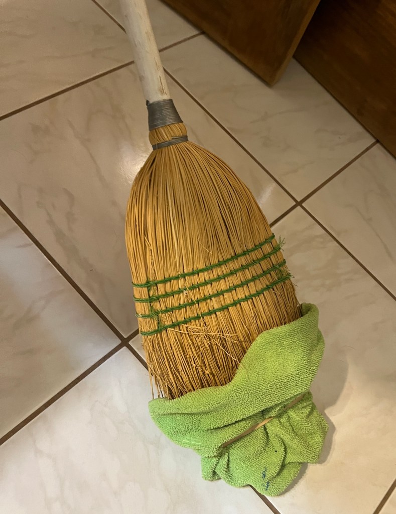 Broom with a cleaning rag mounted with a rubber band
